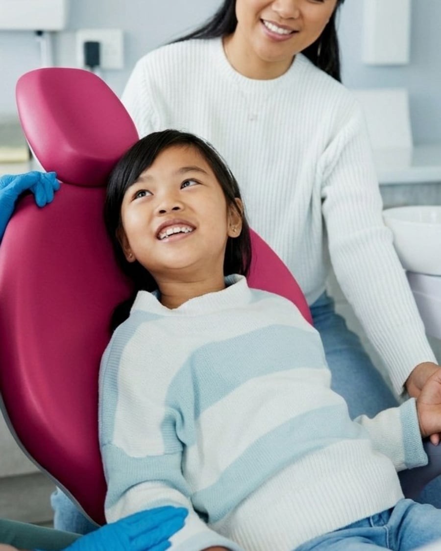 Young child relaxed in the dental chair with a parent alongside at Dr Ray & Partners Dental